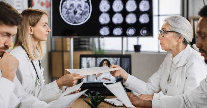 World Alzheimer'S Month In Memory Care In Park Cities 1 Medical Professionals In White Lab Coats Discussing Patient Charts In A Room With Brain Scan Images Displayed On A Large Screen.